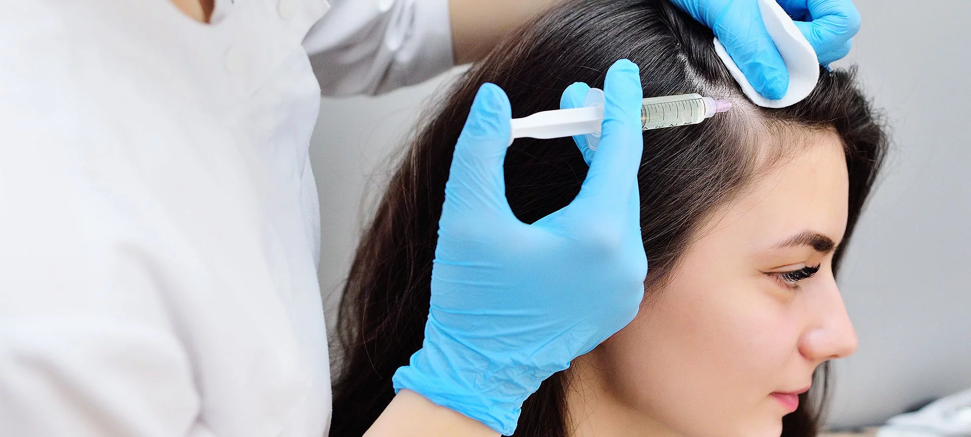 Injection treatment being given into the scalp along a hair parting