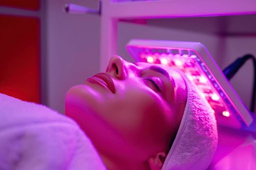 Patient lying under a light therapy panel during treatment